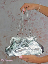 Poche métallique ornée d'ailes en strass