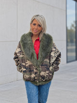 Chaqueta denim camuflaje y animal print con pelo verde — frente con manos en bolsillos