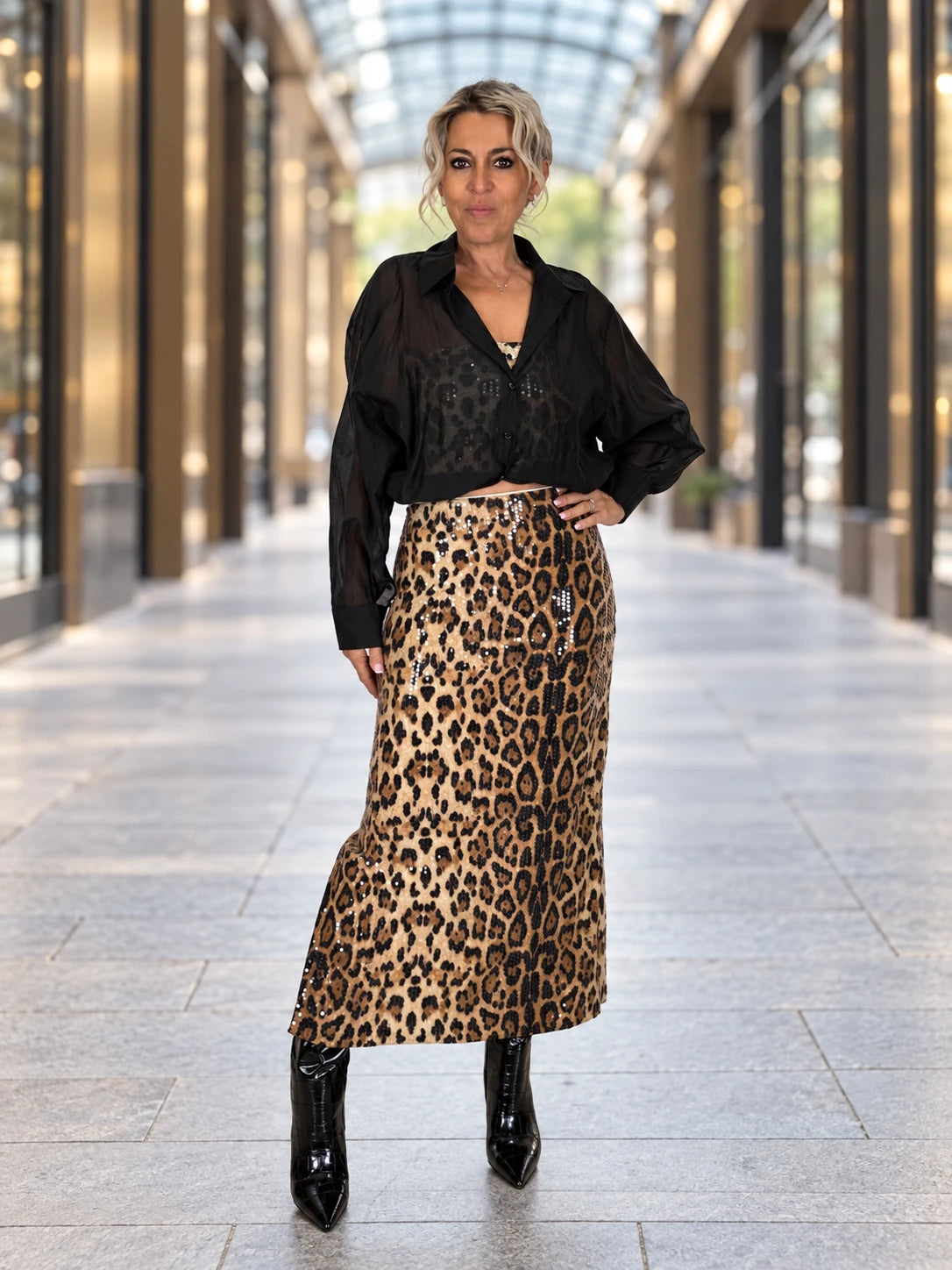 Carol con falda midi de lentejuelas animal print en una galería luminosa