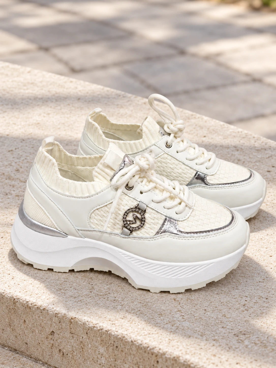 Zapatillas Confort blancas con plataforma y detalles plateados sobre piedra clara